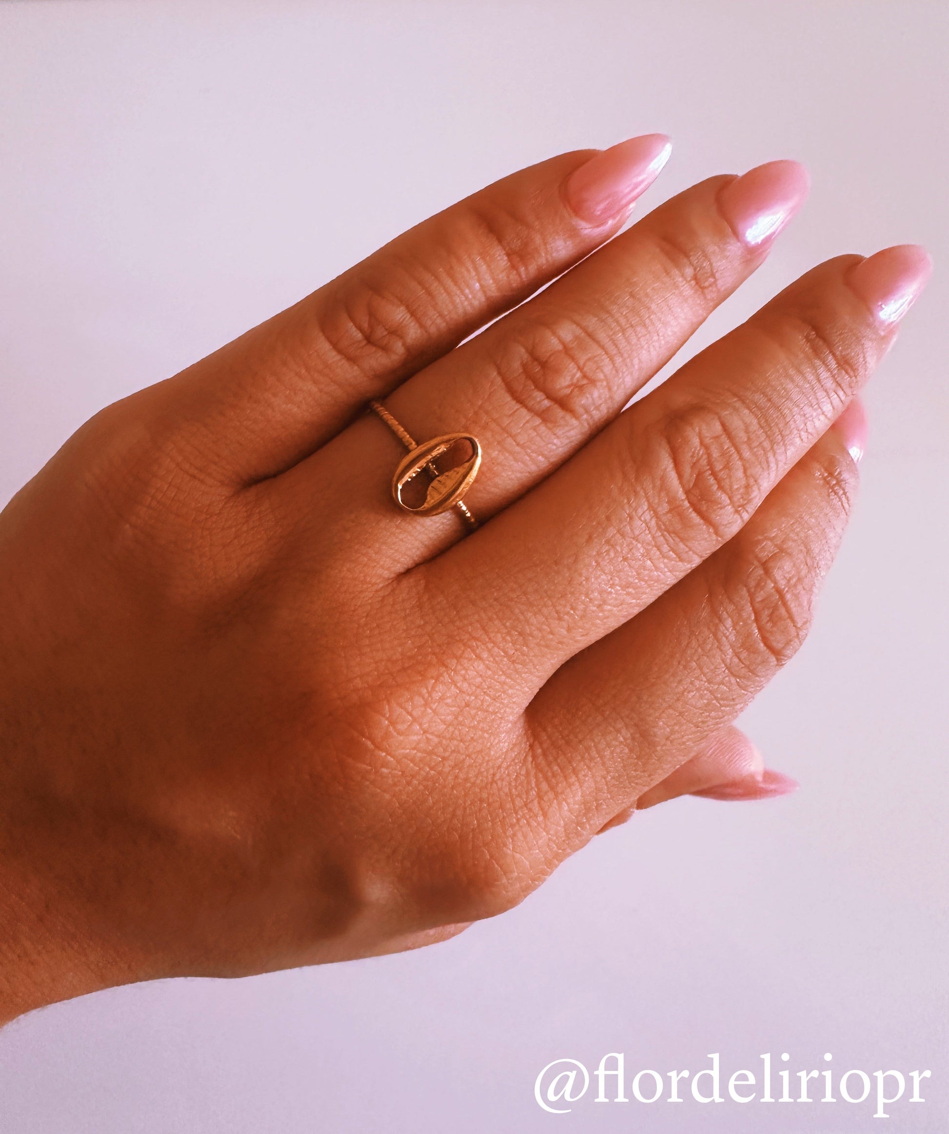 Beach shell ring in 18k gold plated finish with an adjustable band, featuring a delicate shell design on a hand model.